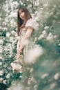 Woman in Puff Dress Standing on a Flower Field while Looking at the Camera