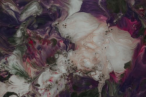 Abstract background representing stains of spilled paint of different dark colors and white pearl paint with little bubbles while making fluid art