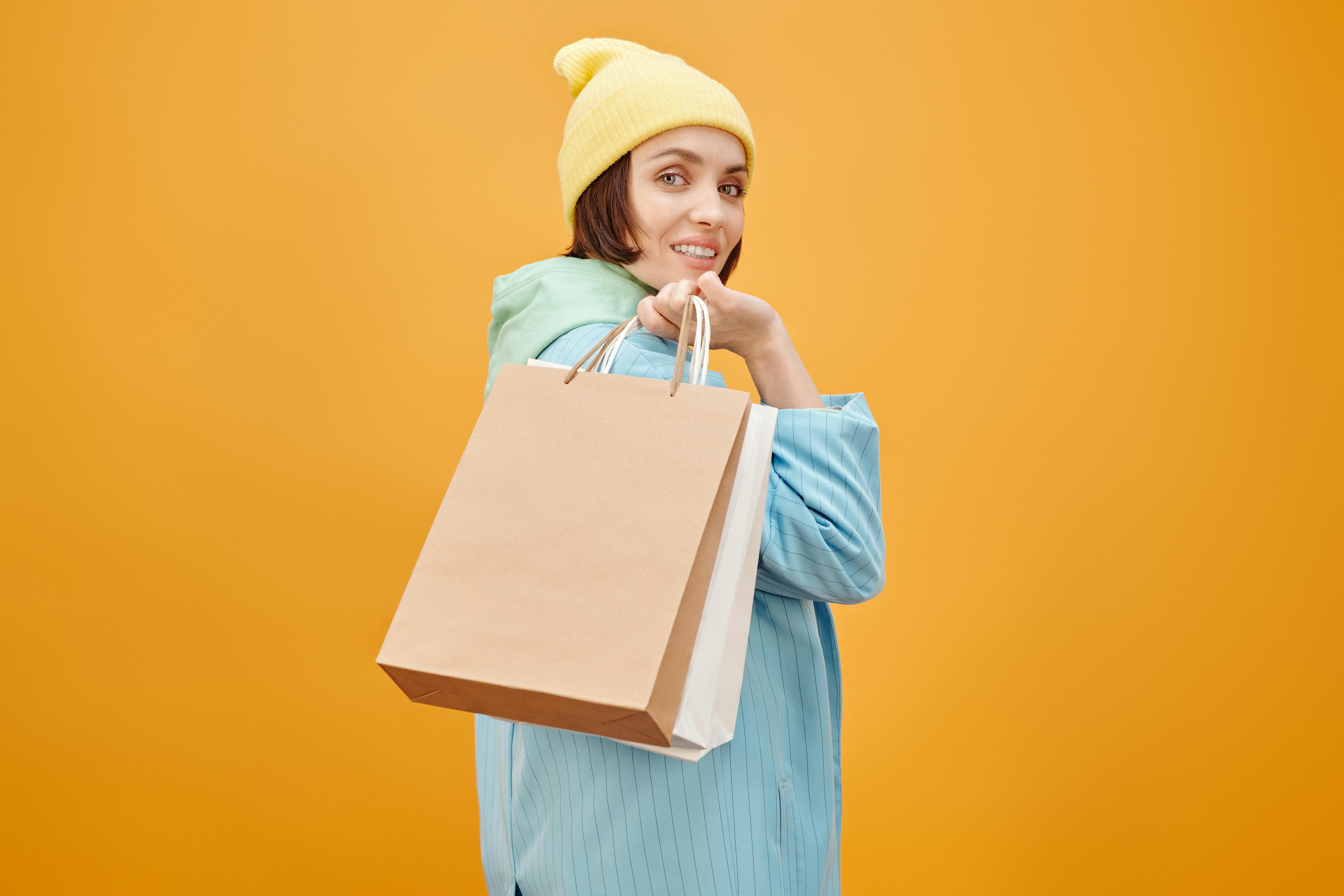 woman wearing yellow beanie holding shopping bags