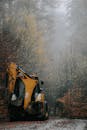 Digger on road near forest in autumn
