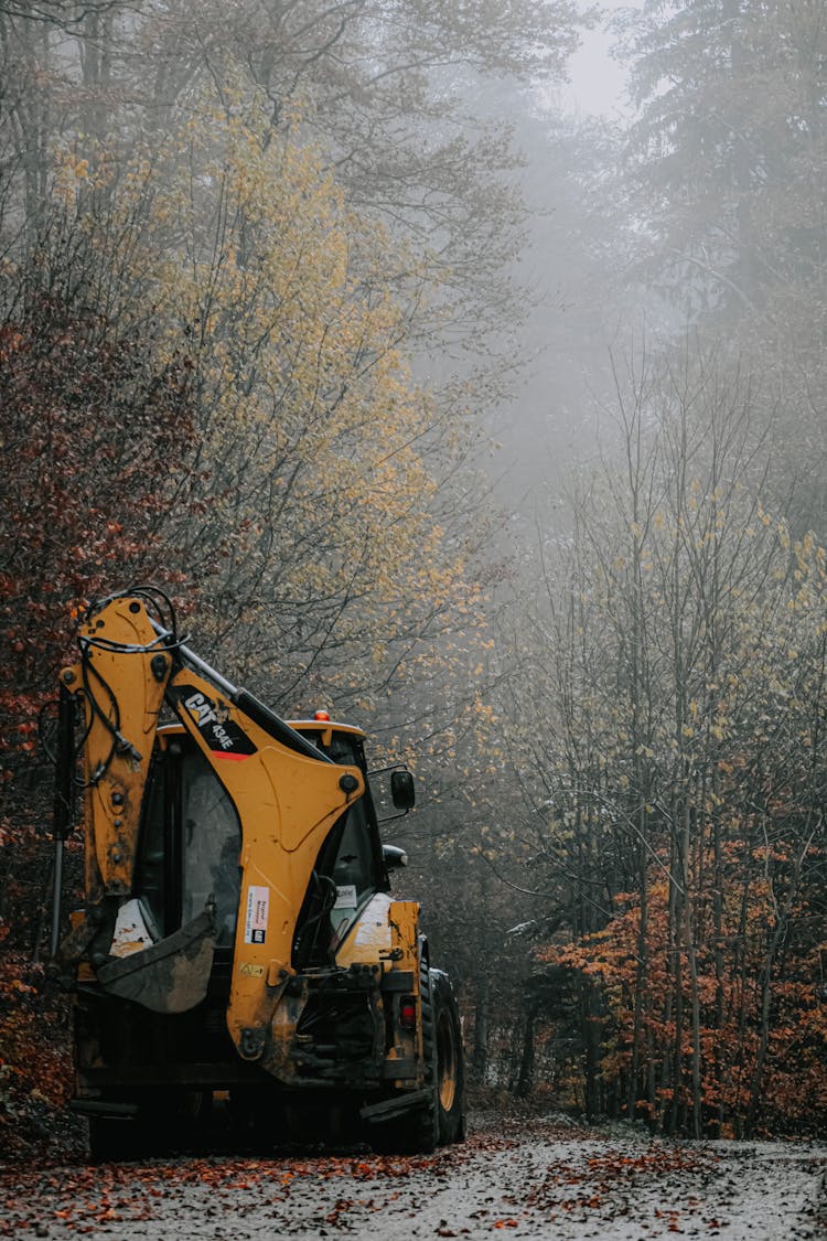 Digger On Road Near Forest In Autumn