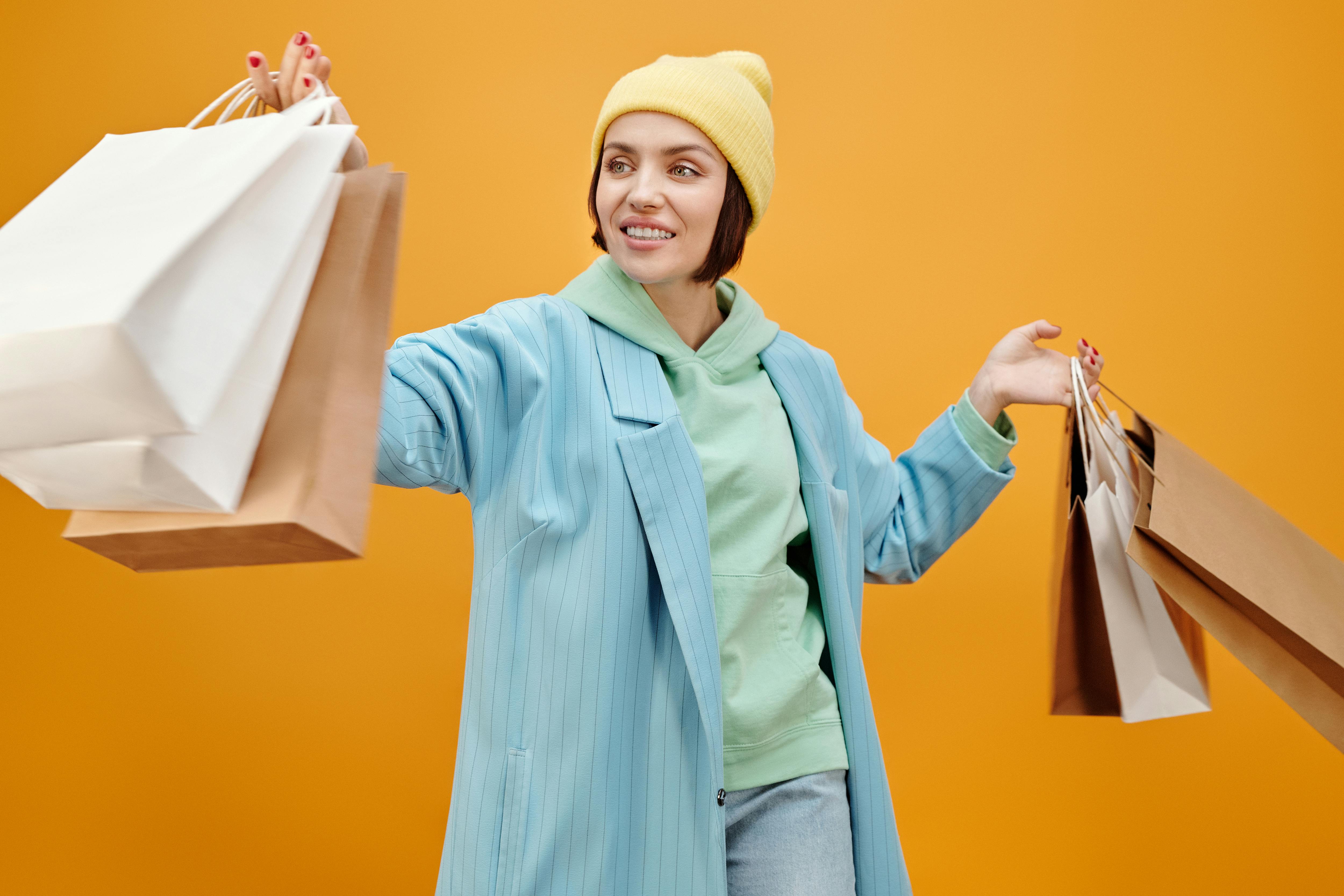 a happy woman carrying paper bags while looking afar