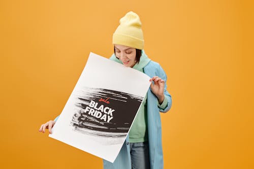 Free Женщина в желтой вязаной шапочке с белой бумагой для принтера Stock Photo