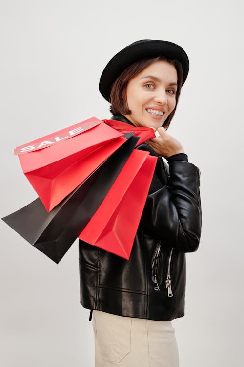 Woman in Black Leather Jacket Holding Shopping Paper Bags