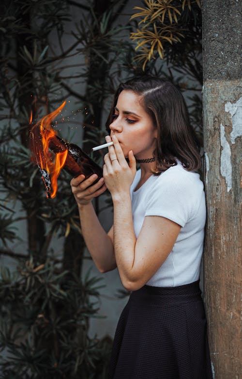 A Woman in White Crew Neck T-shirt Smoking Cigarette