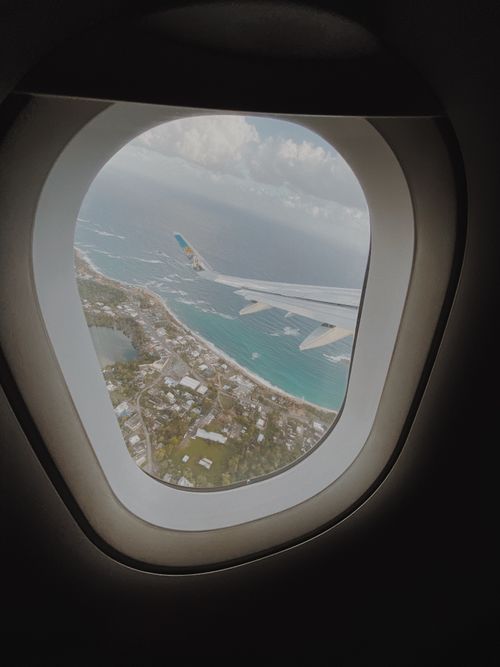 Free Captivating aerial view from airplane window showing San Juan's stunning coastline. Stock Photo