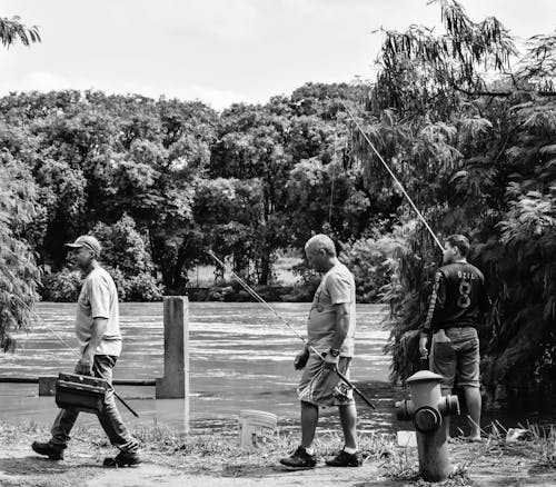 Grayscale Photo of Men Holding Fishing Rods