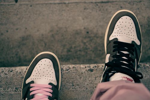 Free From above of feet in sneakers with different laces standing on edge of asphalt steps in city Stock Photo
