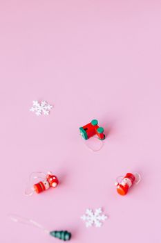 粉红色背景上，圣诞装饰品和雪花营造出异想天开的节日氛围