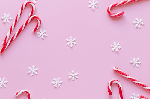 Red and White Stripes Candy Canes on Pink Surface