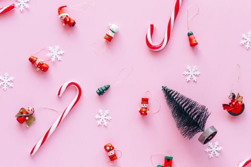 Free Colorful Christmas decorations, candy canes, and snowflakes on a pink background, perfect for holiday celebrations. Stock Photo