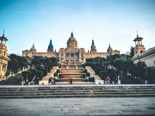Free Exterior of historic National Art Museum of Catalonia with dome and spires surrounded with lush gardens and tall staircases Stock Photo