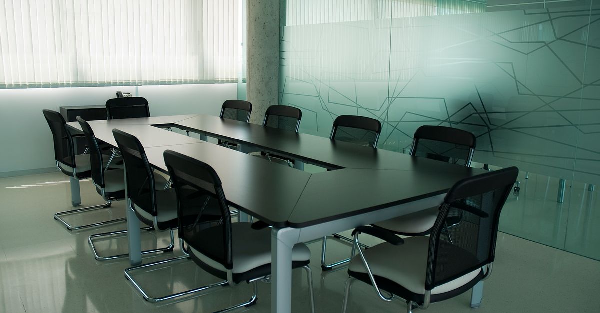 Elegant conference room with sleek black chairs and a modern glass wall design.