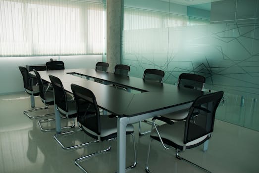 Elegant conference room with sleek black chairs and a modern glass wall design.