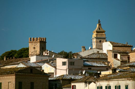 View of historic towers and rooftops in Spoltore, Italy. Captured under a clear blue sky.