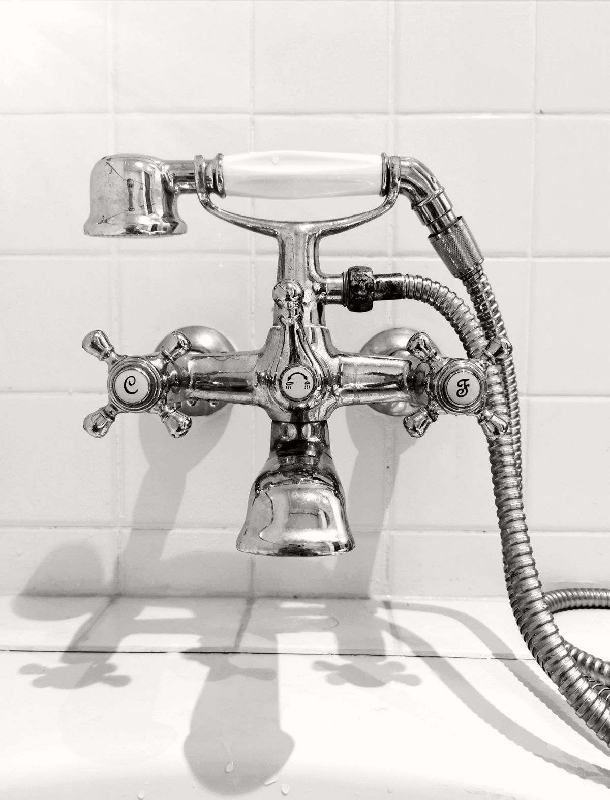 Elegant vintage chrome faucet in black and white, showcasing classic design and plumbing details. Stock Photo.
