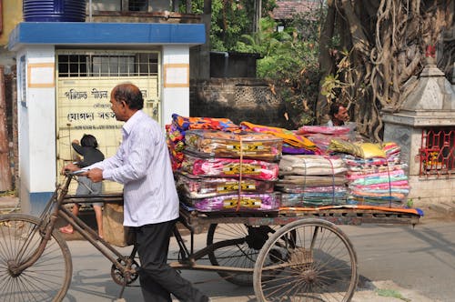 Man Pushing a Tricycle with Blankets