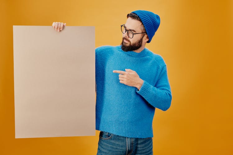 Man In Blue Sweater Holding A Blank Paper