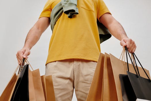 A young adult carrying paper shopping bags symbolizes retail therapy and consumerism indoors.