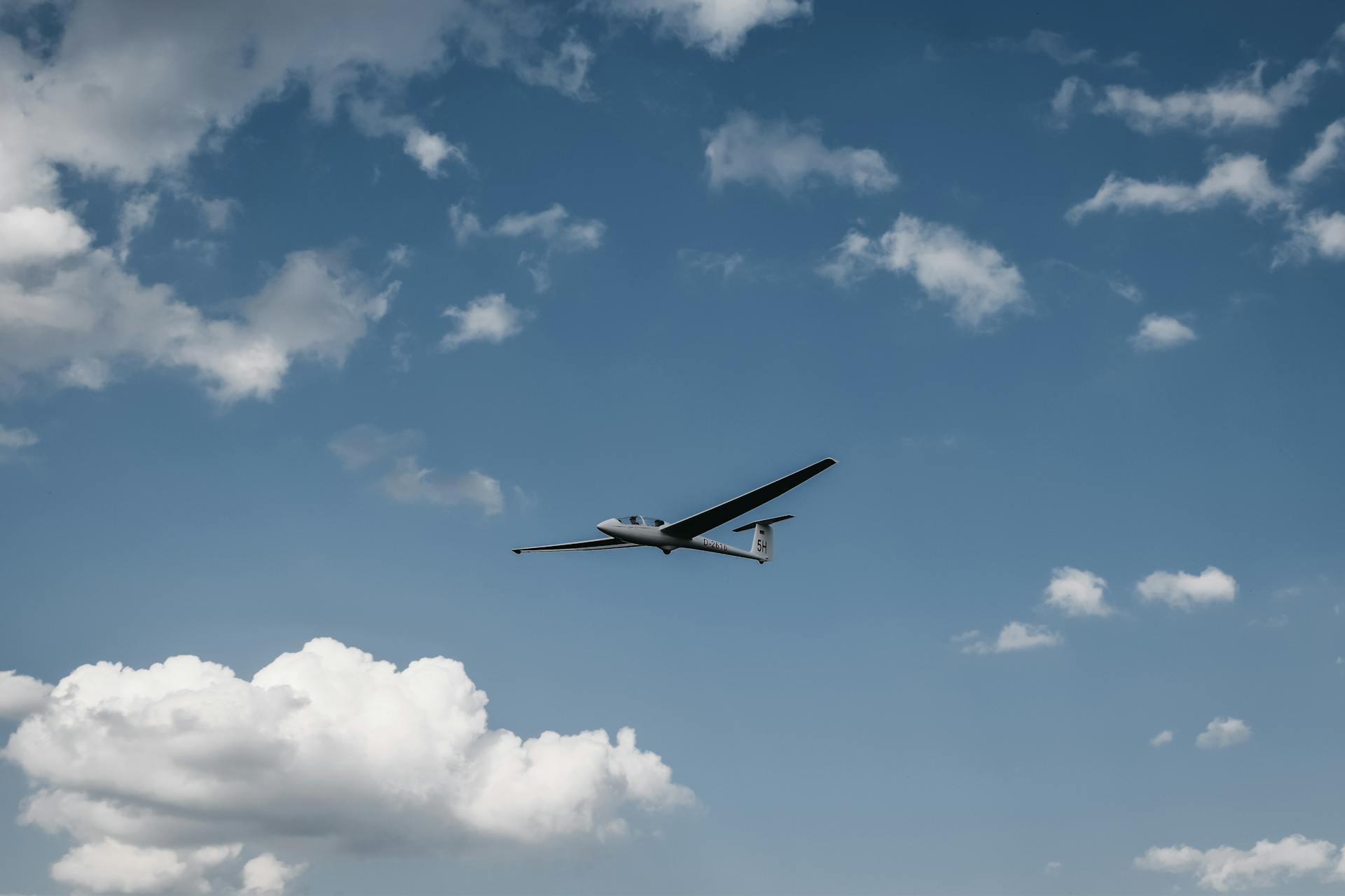 Modern glider flying in blue sky