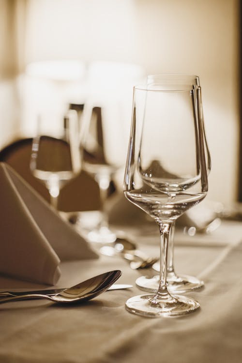 Crystal wineglasses and cutlery served on table