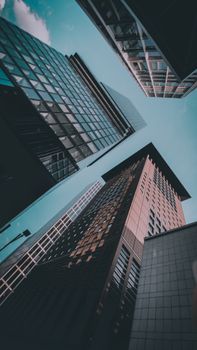 Low angle view of modern skyscrapers against a twilight sky, showcasing architectural designs.