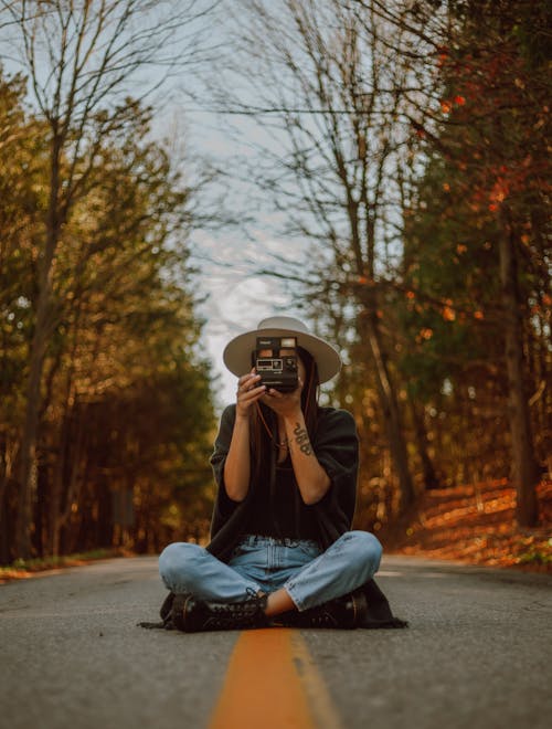 Fotografo Femminile Senza Volto Che Si Siede Con La Macchina Fotografica Sulla Strada In Campagna