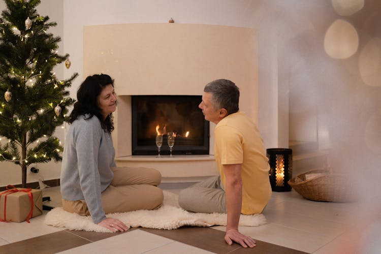 A Couple Sitting Near The Fireplace