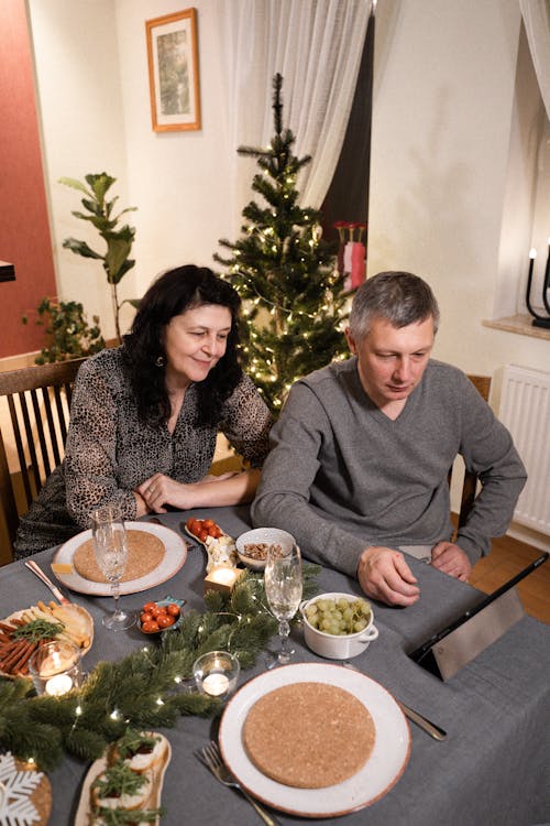 Couple Sitting By A Dining Table Having A Video Chat