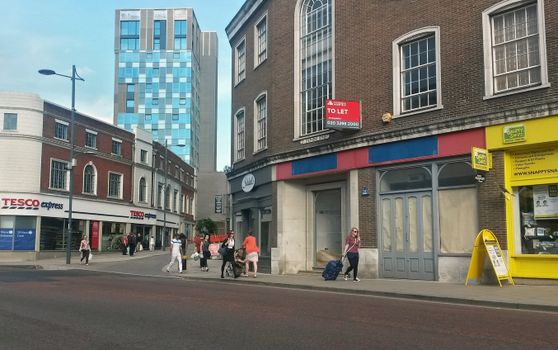 Urban street view in Norwich showcasing diverse architecture and pedestrians.
