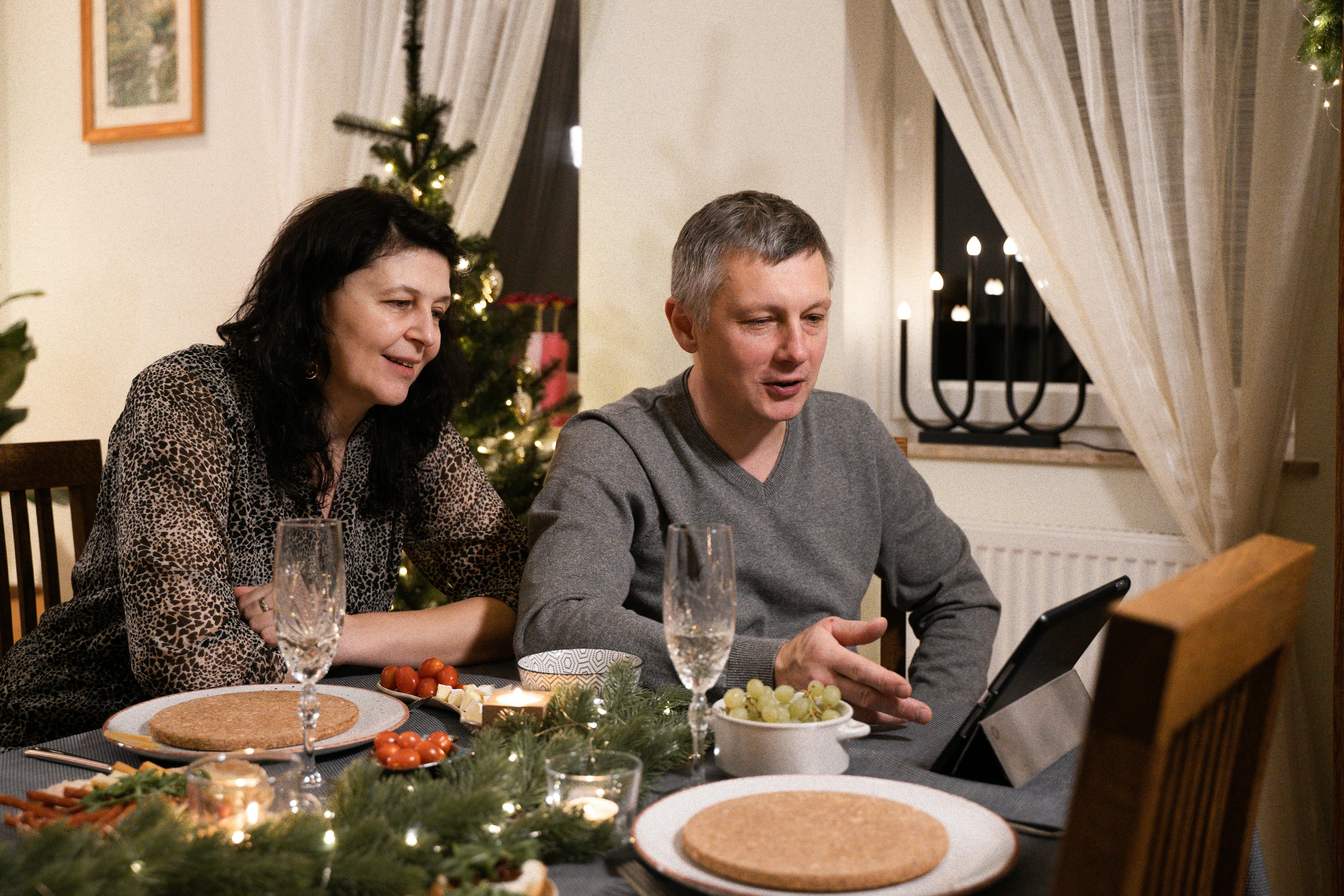 man and woman looking at the screen of a tablet