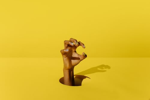 黃色表面上的棕色木製人形圖
