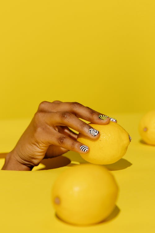 戴銀戒指，拿著黃色水果的人