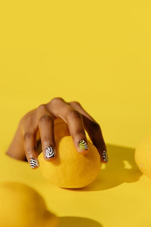 戴银戒指，拿着黄色水果的人