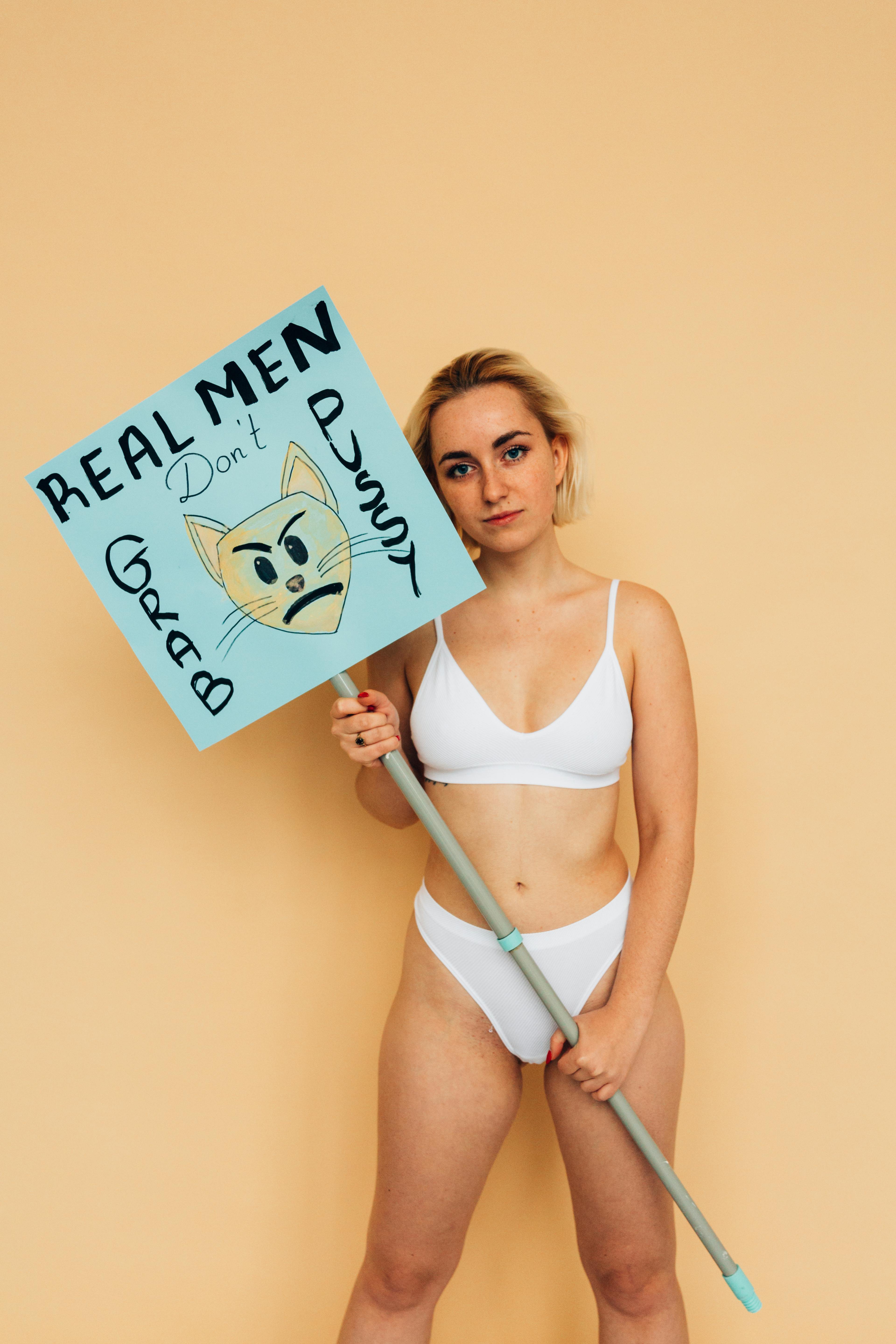 Woman Wearing Underwear Holding a Placard on Stick · Free Stock Photo