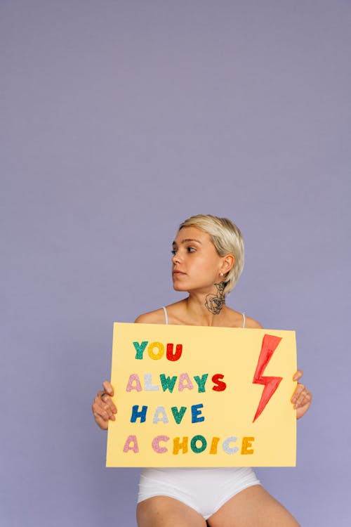 Free Person Looking Sideways While Holding a Placard Stock Photo