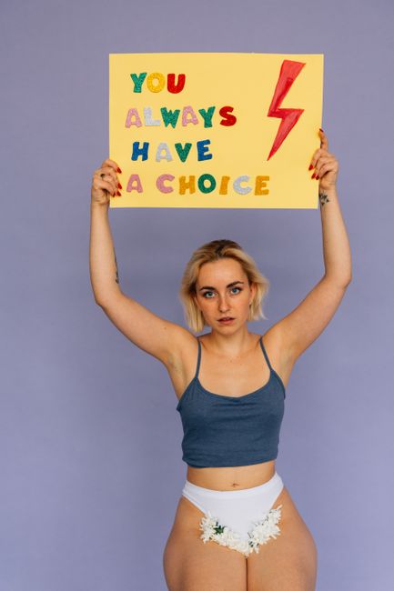 Woman standing with sign 'You Always Have a Choice', symbolizing empowerment and choice.