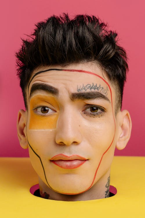 A Man with Tattoo on His Face and Neck Seriously Looking at the Camera
