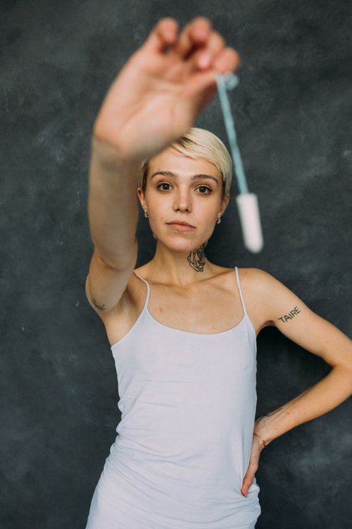 Free Portrait of a young woman confidently holding a tampon, emphasizing menstrual health awareness. Stock Photo