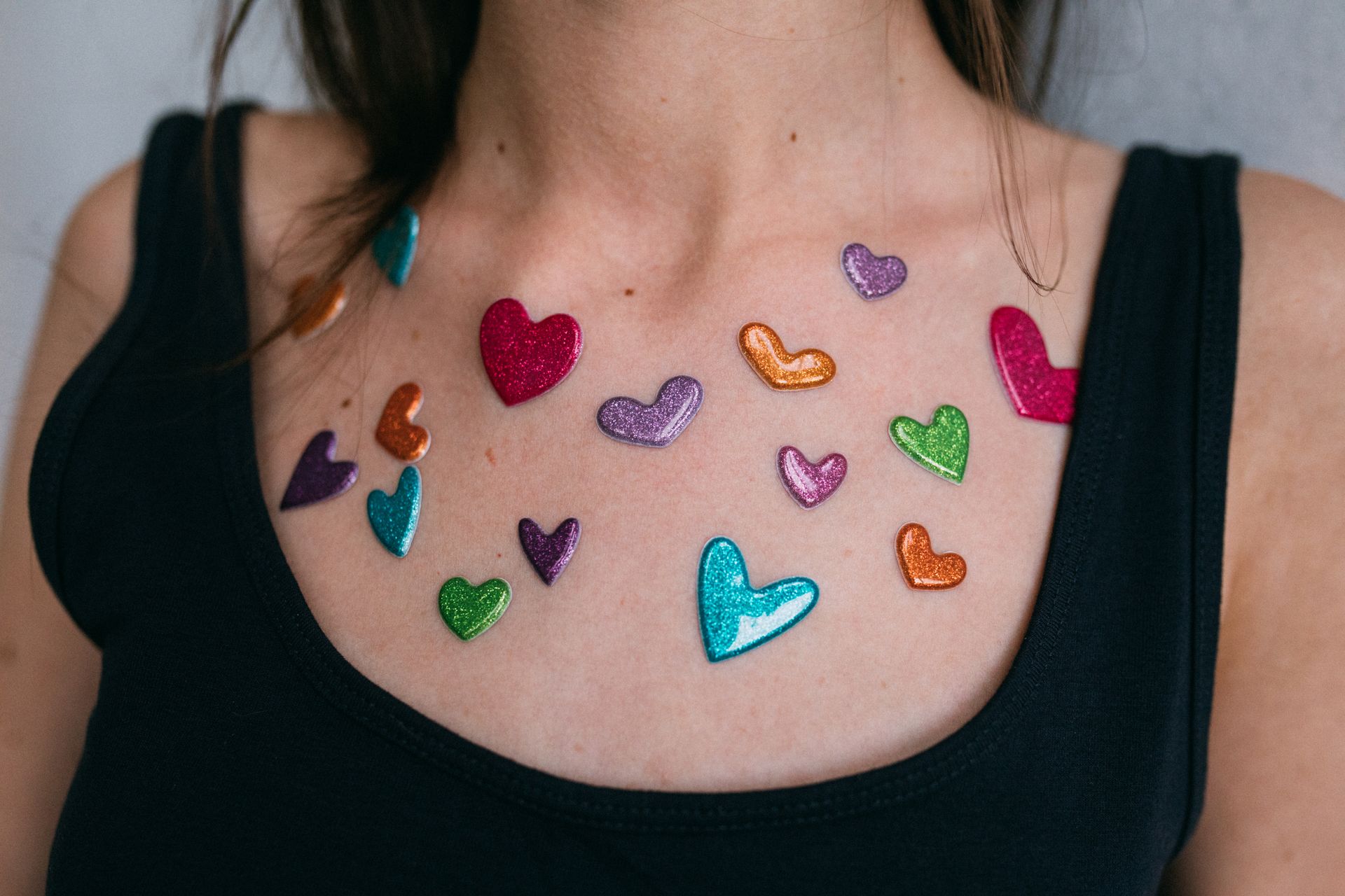 Close-Up Shot of Colorful Heart Stickers on a Person's Chest