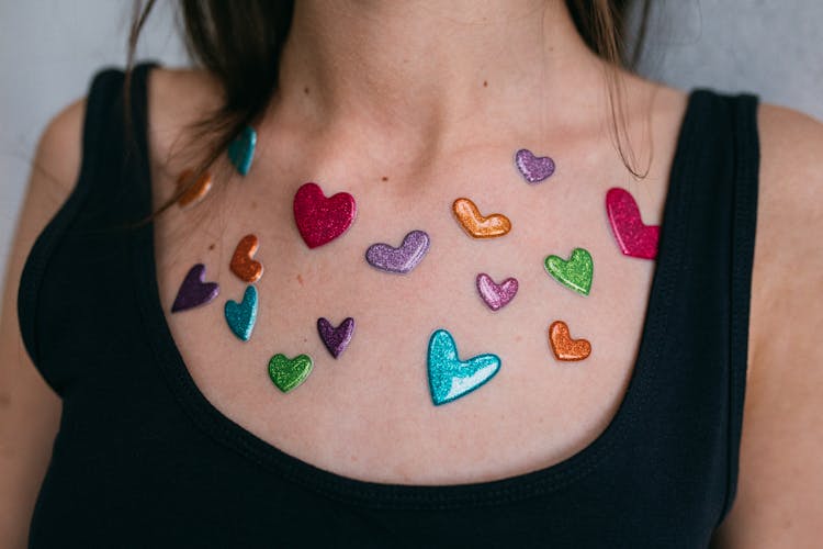 Close-Up Shot Of Colorful Heart Stickers On A Person's Chest