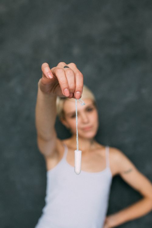 Free Close-up portrait of a confident woman holding a tampon, promoting menstrual hygiene awareness. Stock Photo
