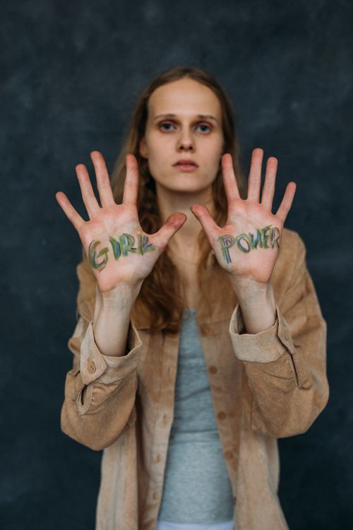 Free Portrait of a woman showing 'Girl Power' painted on her hands, embracing feminism and positivity. Stock Photo