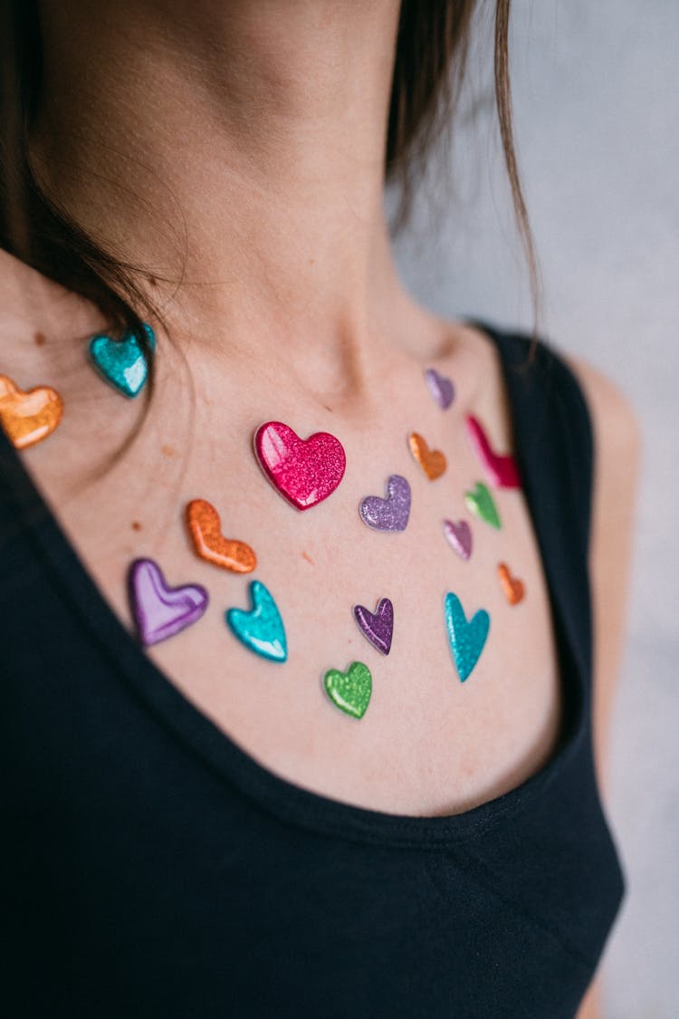 Close-Up Shot Of Colorful Heart Stickers On A Person's Chest