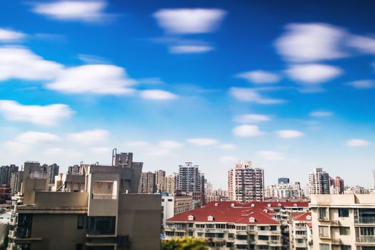 生动的蓝天上散布着云朵，映衬着一座动态的城市天际线