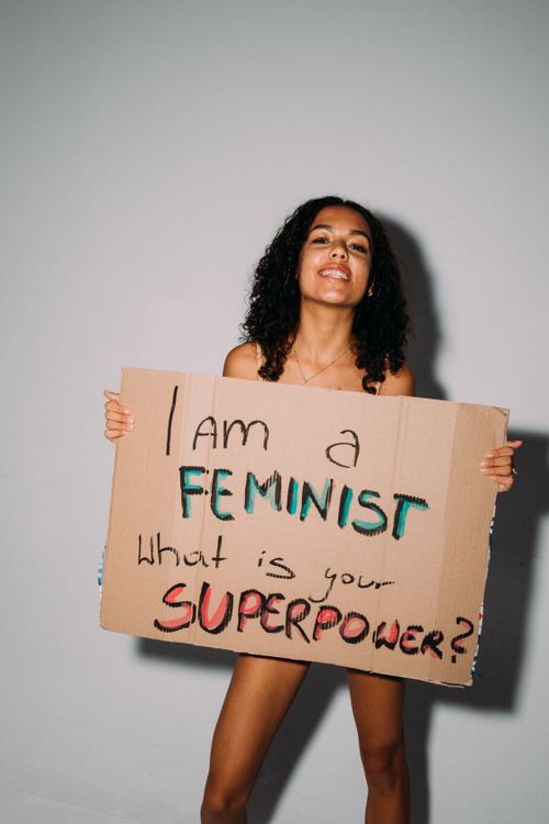 Free Confident woman proudly holds a sign promoting feminism and empowerment. Stock Photo