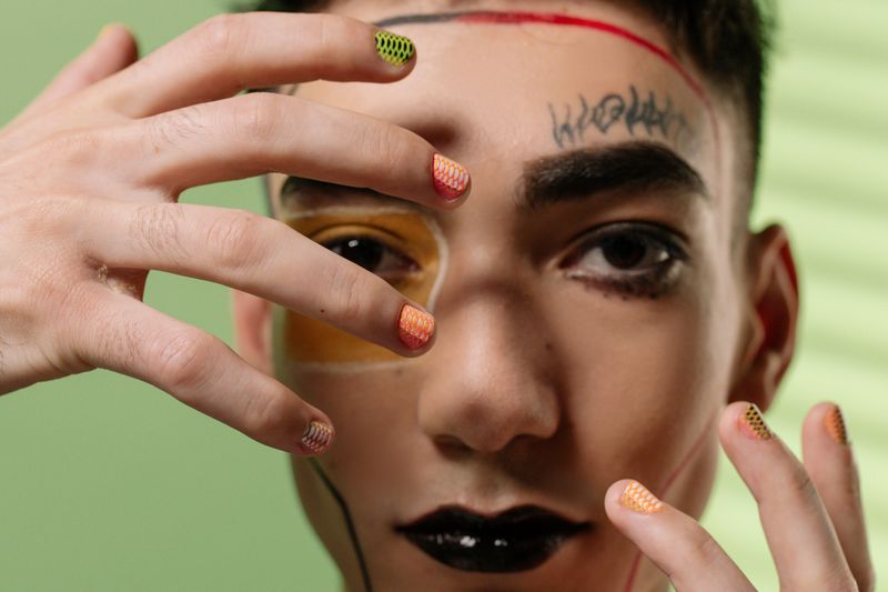 Uñas pintadas con motivos de colores cálidos en luz suave