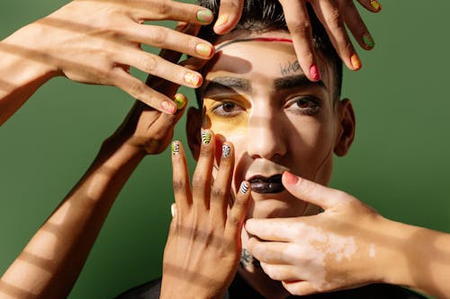 Free Hands with Manicured Nails on a Man's Face Stock Photo
