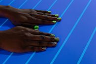 Person With Green Manicure Holding Blue Surface