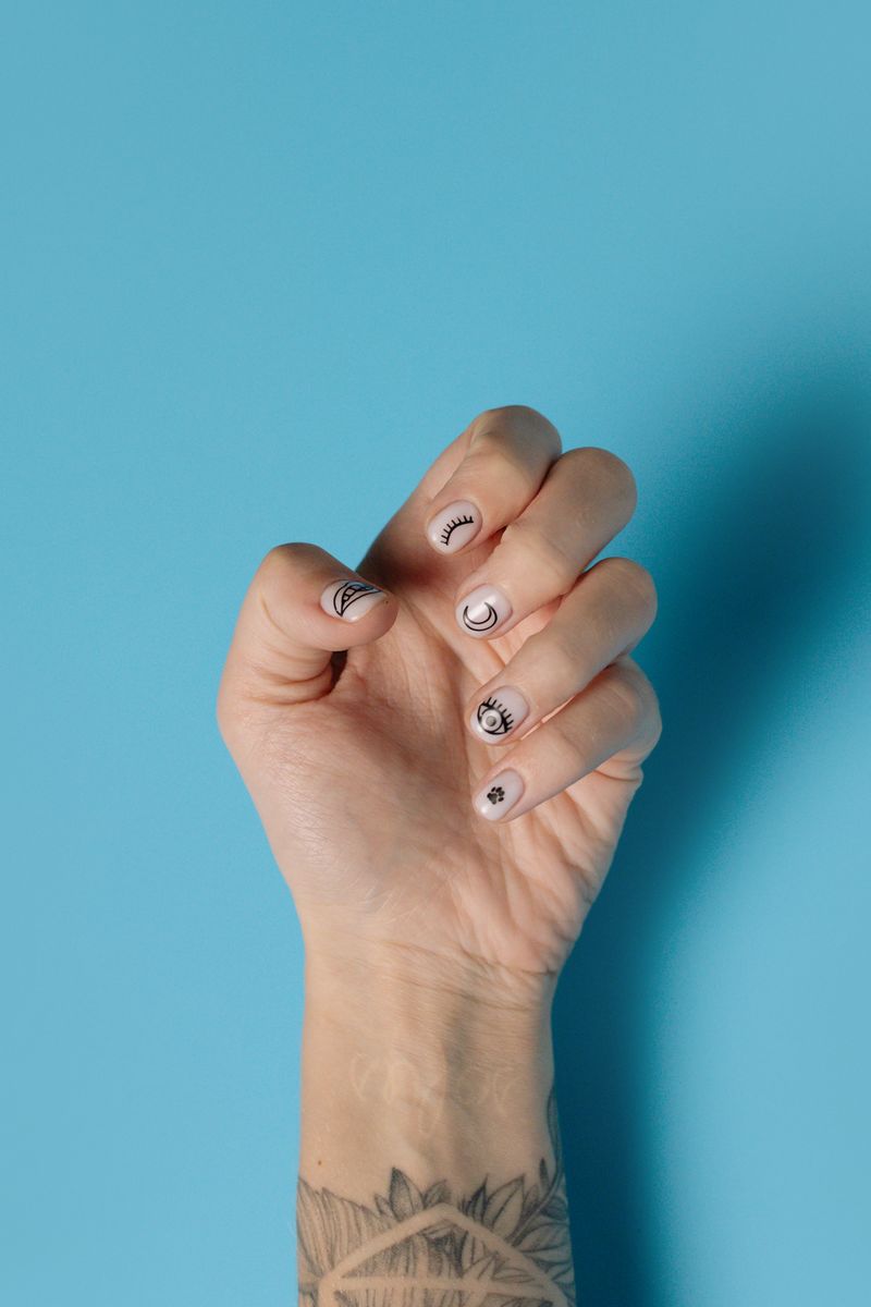 Detalle de uñas con nail art de colores vivos y trazos a mano